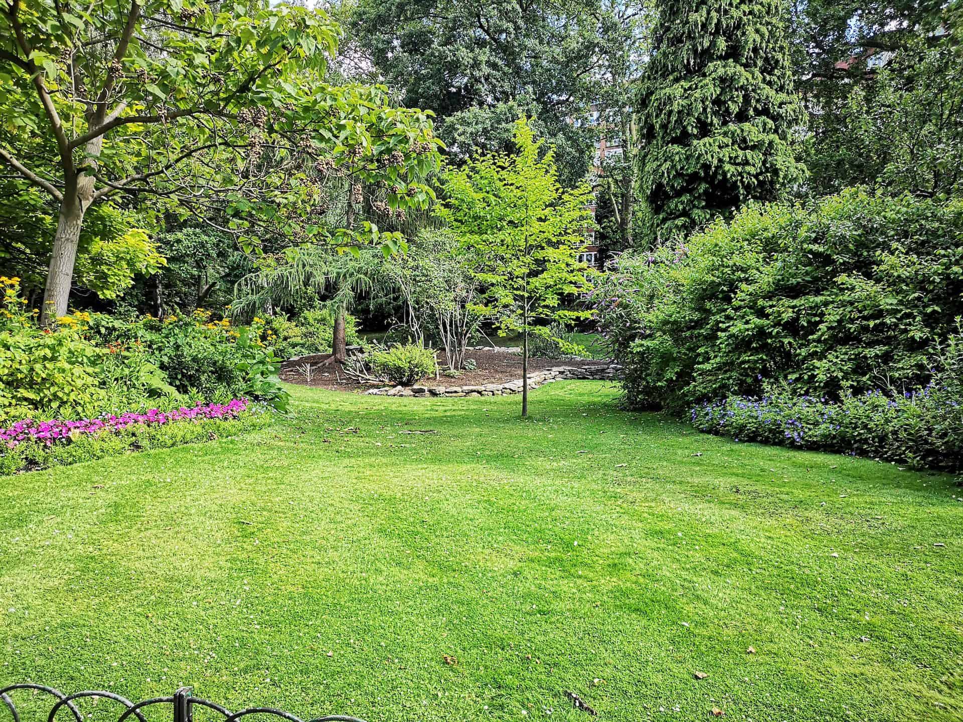 Lush garden with flower borders wrapped around a neat lawn