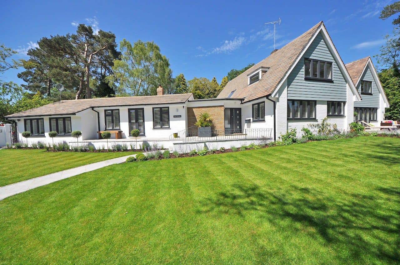 Large suburban house with a wide, freshly mowed front lawn